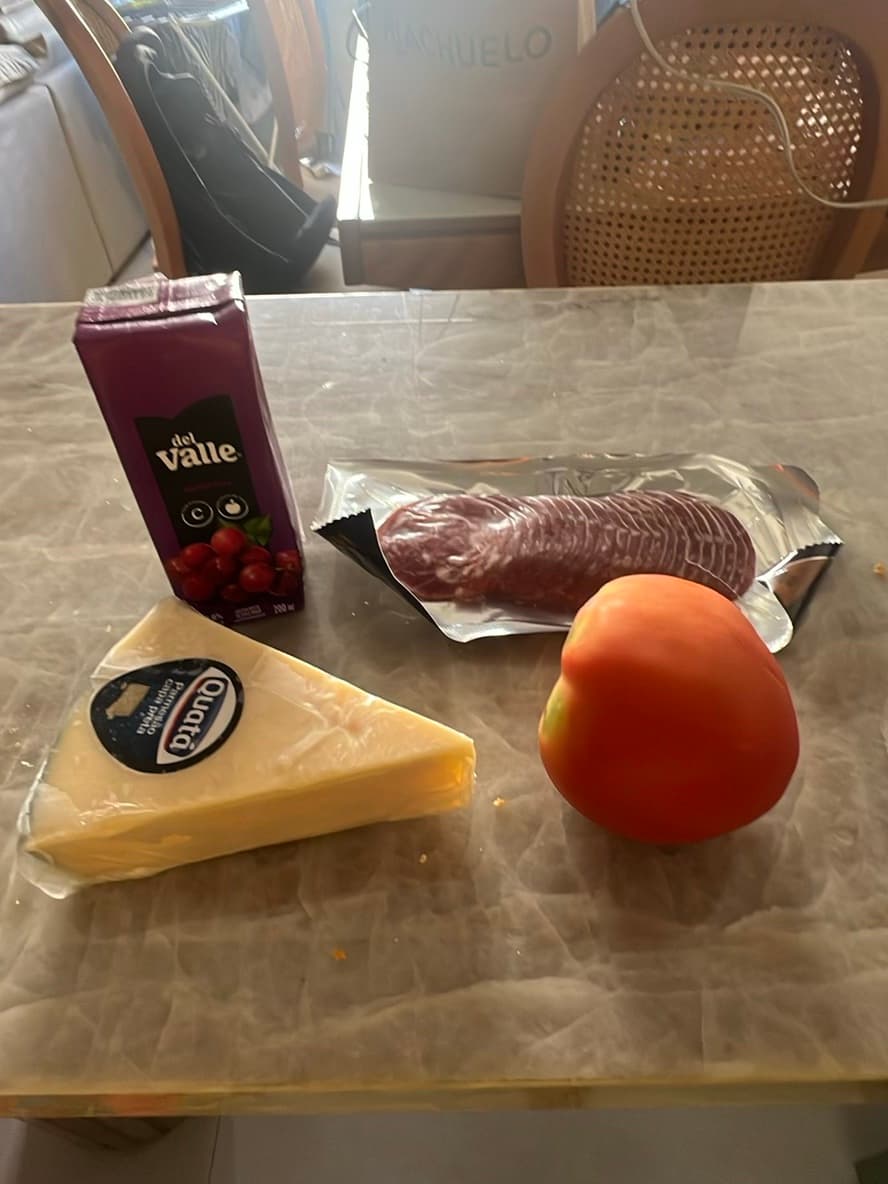 Tábua de queijo com presunto, tomate e suco de uva
